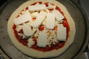 Kecskesajtos pizza készítése: kecskesajt feltét