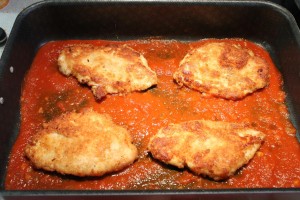 Parmezános csirke készítése: paradicsomszósz és csirke a tepsiben