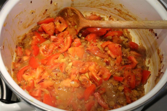 Sárgaborsó curry készítése: add hozzá a paradicsomot és egy kevés vizet