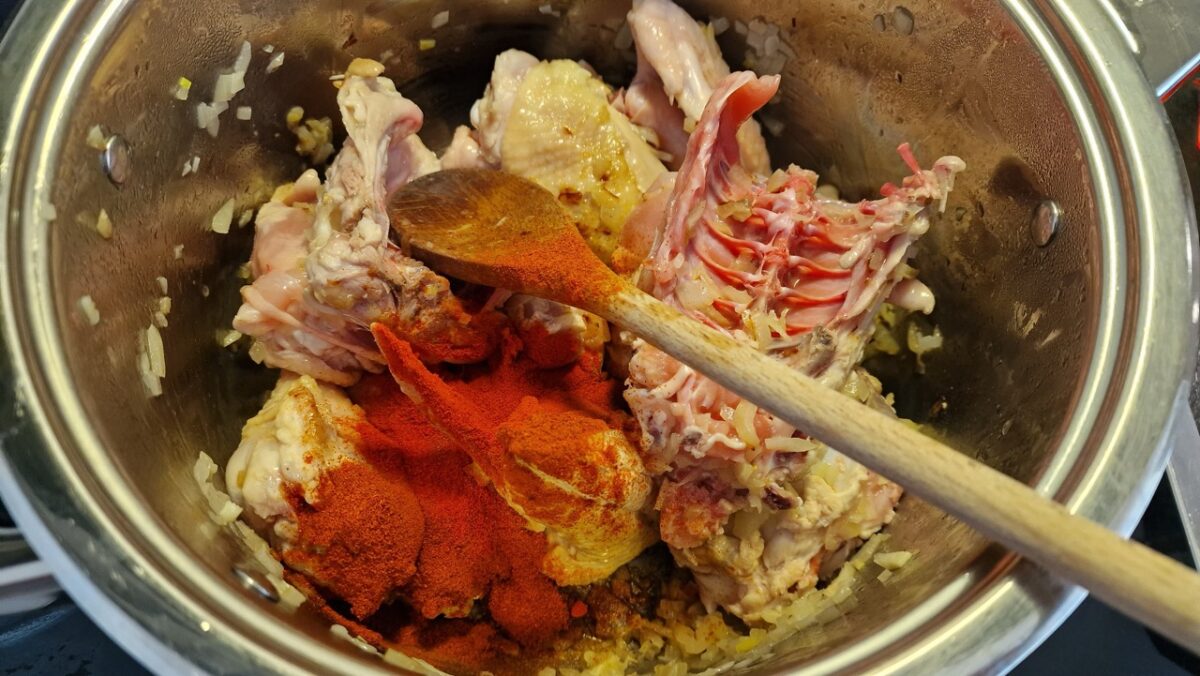 Egész csirkepörkölt fűszerezése pirospaprikával